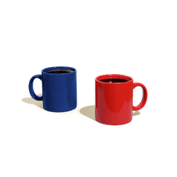 Two adjacent full coffee mugs, one red and one blue.