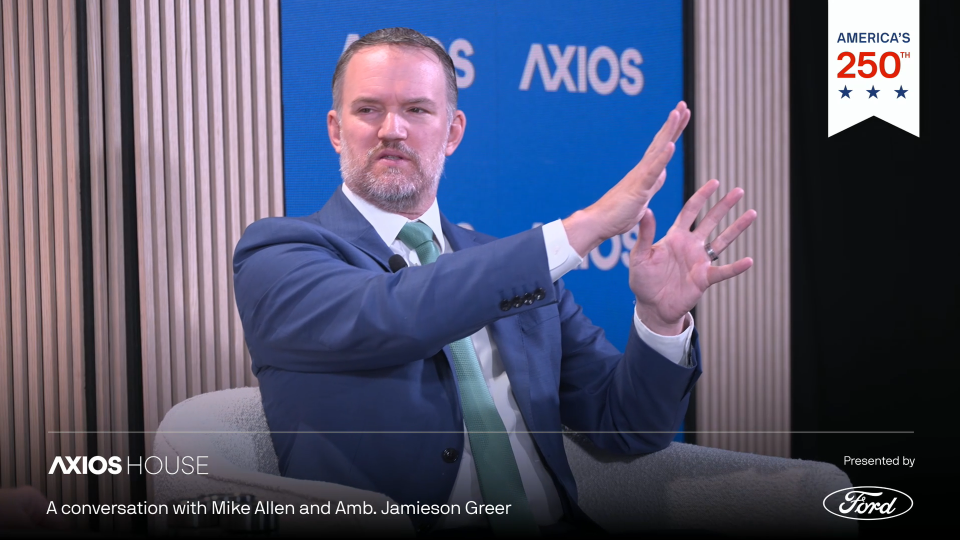U.S. Trade Representative Jamieson Greer gestures while speaking during an Axios House interview, seated onstage against a backdrop with Axios branding.